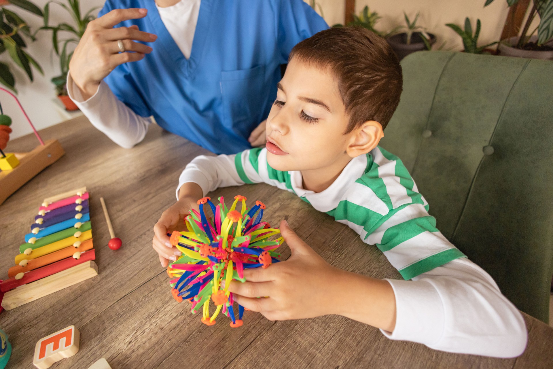 Nurse Supports Boy's Therapy with Ball